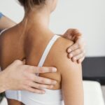 medico-osteopata-masculino-comprobando-escapula-paciente-femenino-1