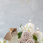 Jasmine essential oil, candles and towels, flowers on a white background. Spa and wellness concept